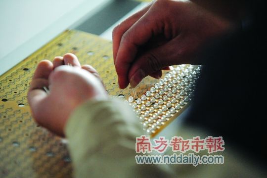 工人忙著安裝用于燈具發(fā)光的LED燈珠，這類工作處于LED燈具生產(chǎn)的最下游。資料圖
